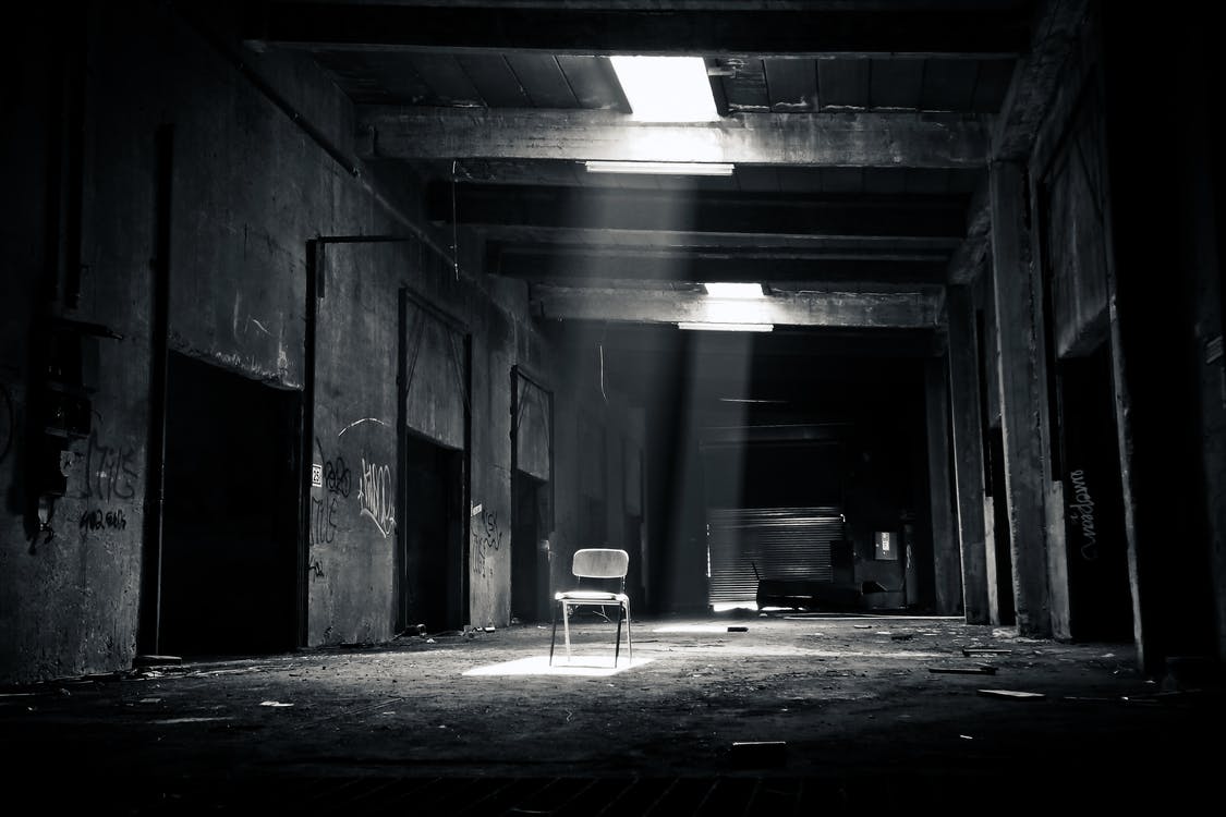 Abandoned attic room with an empty chair. 