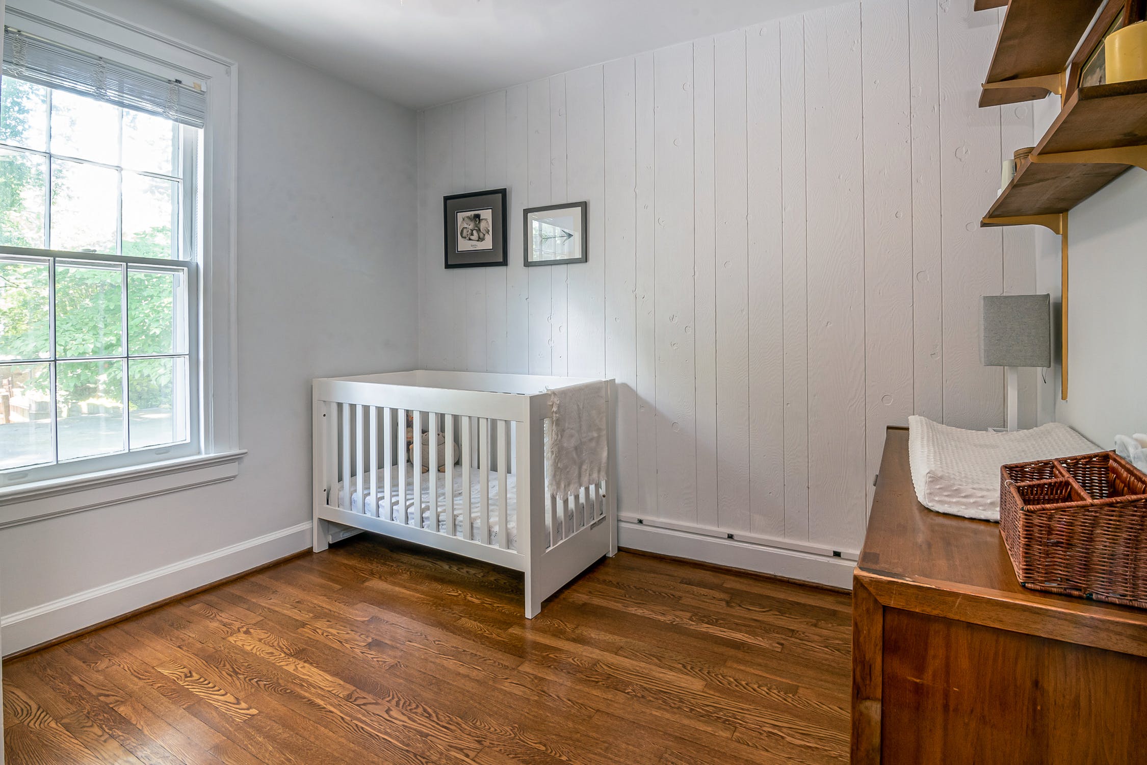 White wooden crib besides a white wall.