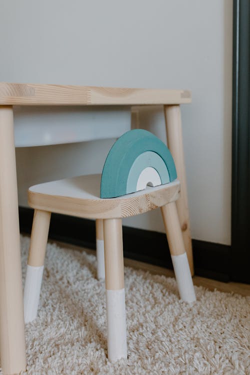 Wooden desk and chair placed on a white rug. 
