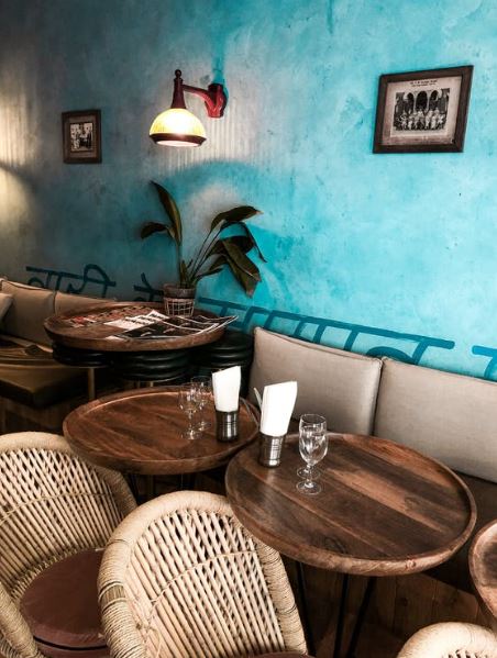 a cozy cafe with wooden tables and wicker chairs with damaged reeds