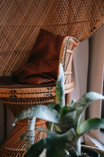 a wicker chair with marks and scratches in the corner of the room