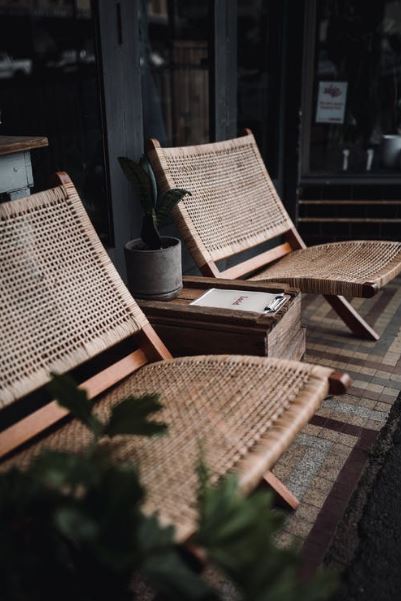 rattan chairs sandwiching a table in a room