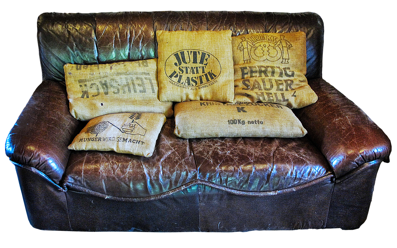 a black leather couch with visible signs of use, with visible scratches