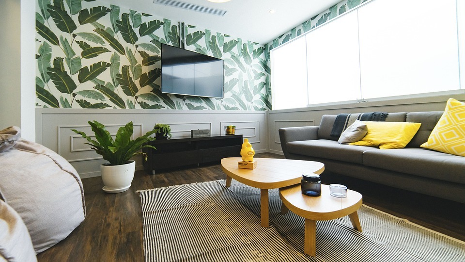 A living room with a gray, green and yellow color scheme with a yellow accent coffee table
