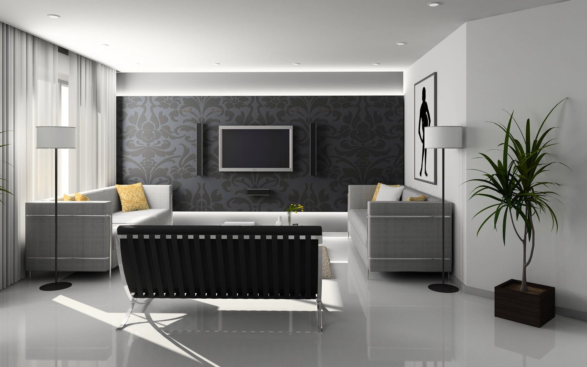 A living room with white walls and a black patterned accent wall, furnished with a black bench and gray couches