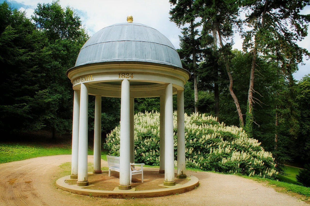 A rotunda gazebo by the park with a bench