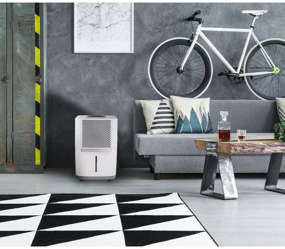 a dehumidifier beside a sofa and the wall of a room