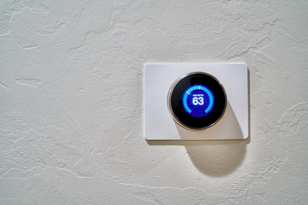 a white thermostat attached on a white wall