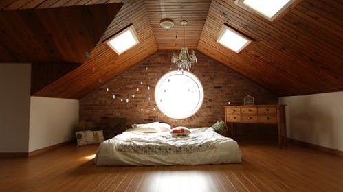 An attic bedroom with wooden paneling and matching floors