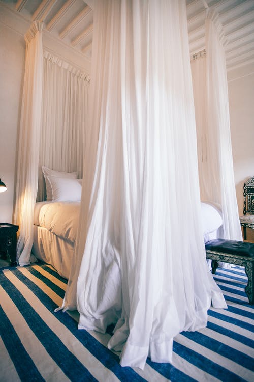 Bed covered with curtains in a canopy form. 
