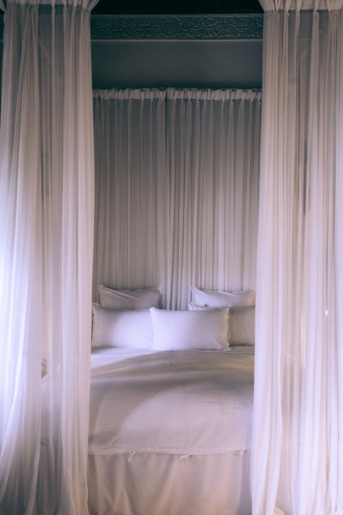 Bed with pillows and curtains 