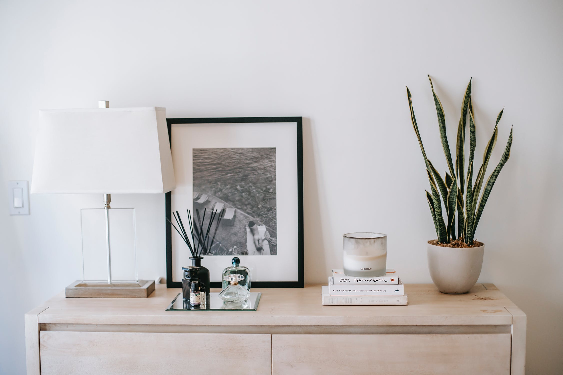 Table with lamp, canvas, plant, and scented candles