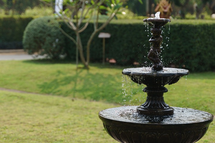 A black water fountain on a large yard