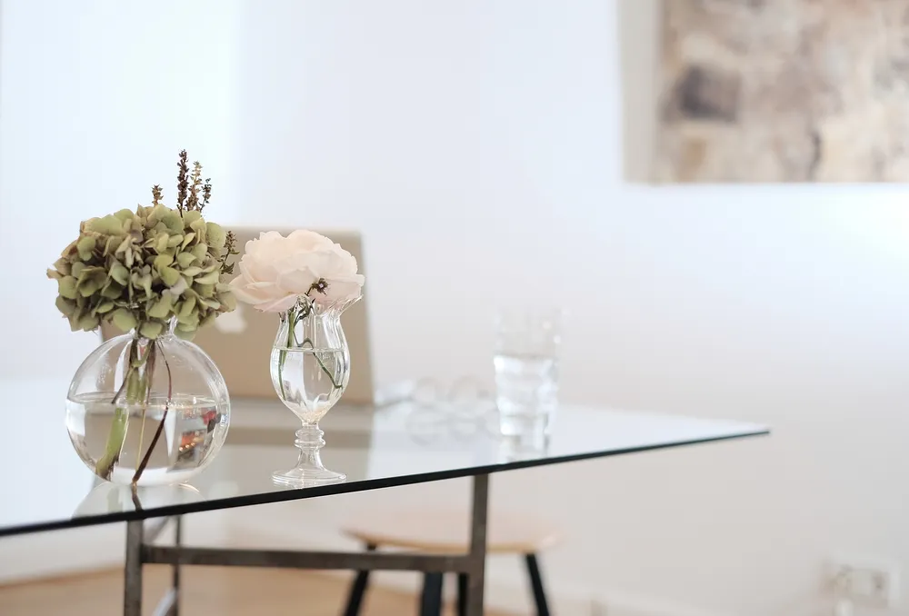A glass dining table with clear vases