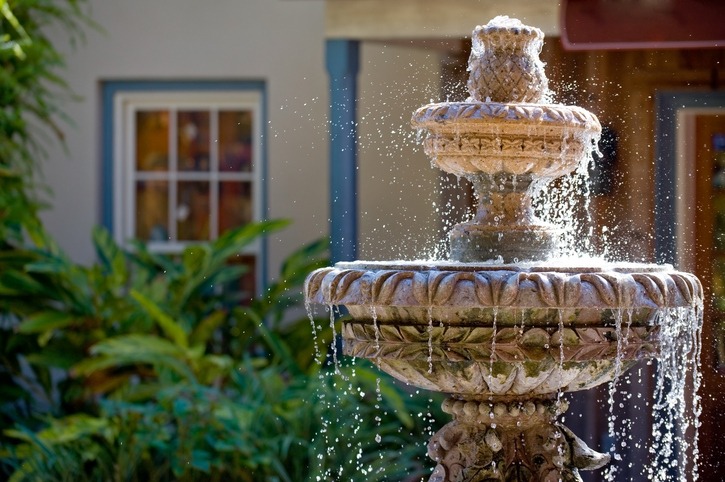 A two-tiered garden fountain flowing with water