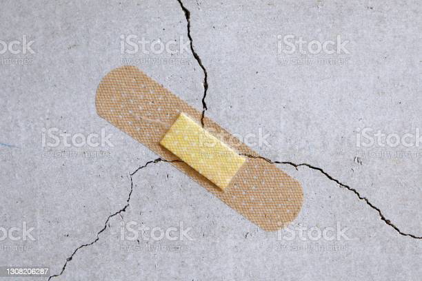 Adhesive plasters are applied to prevent cracks in the concrete wall.
