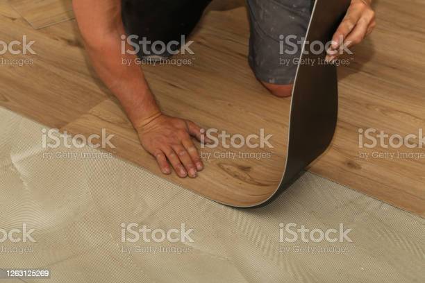 A worker installing a vinyl plank flooring