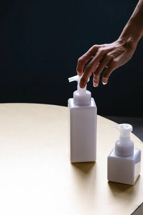 a hand and lotion on a table