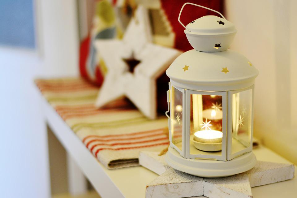 A white lantern on a fireplace mantel