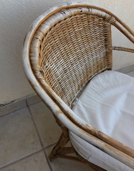 a faded rattan chair near a wall