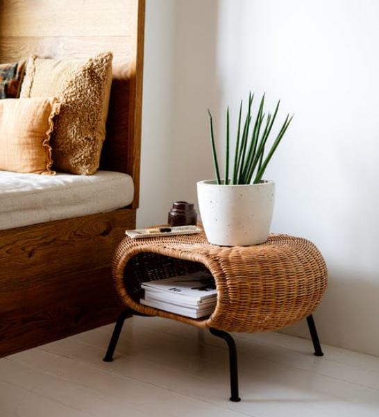 a potted plant on a rattan side table