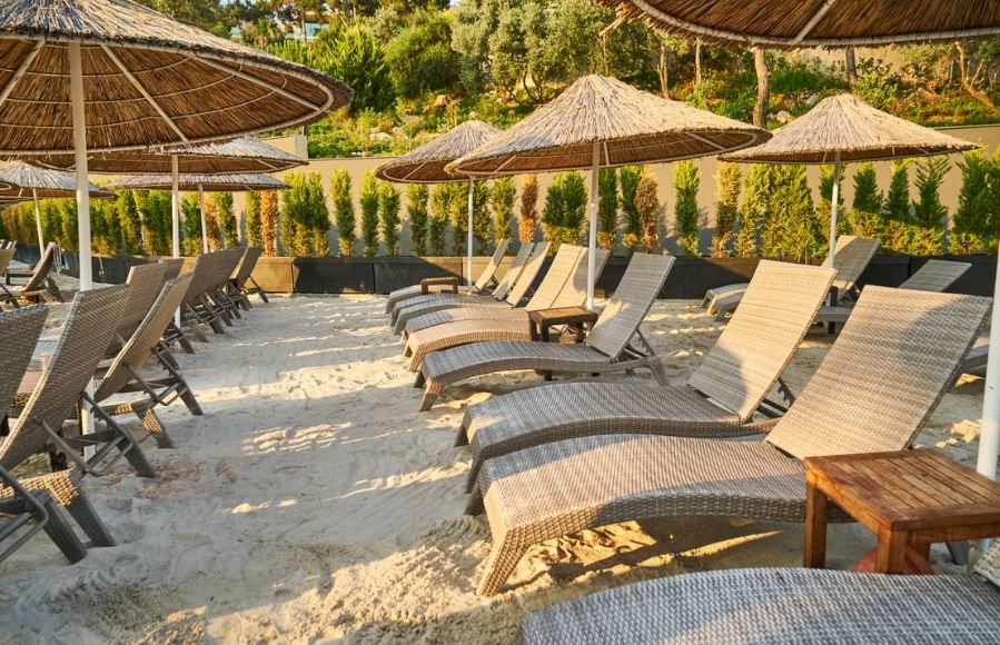 a series of rattan lounge chairs and umbrellas on the beach