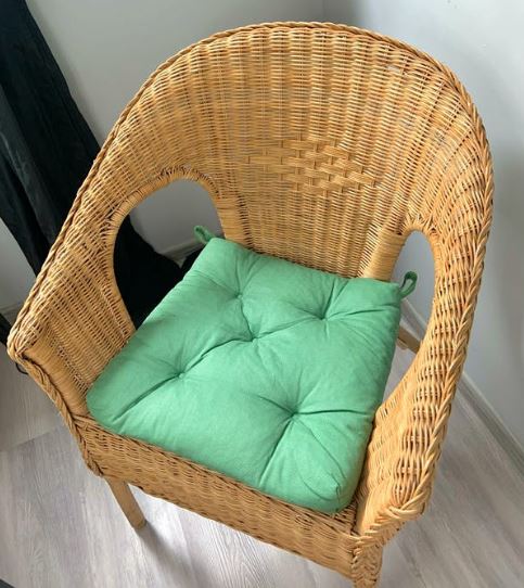 a top view of a rattan chair with a green cushion