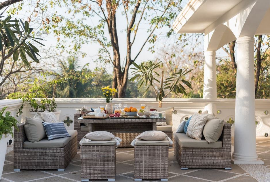 an outdoor patio with a brown wicker furniture sofa set