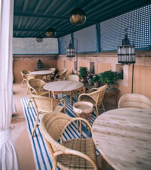 café interior with a terrace and rattan chairs and wooden tables