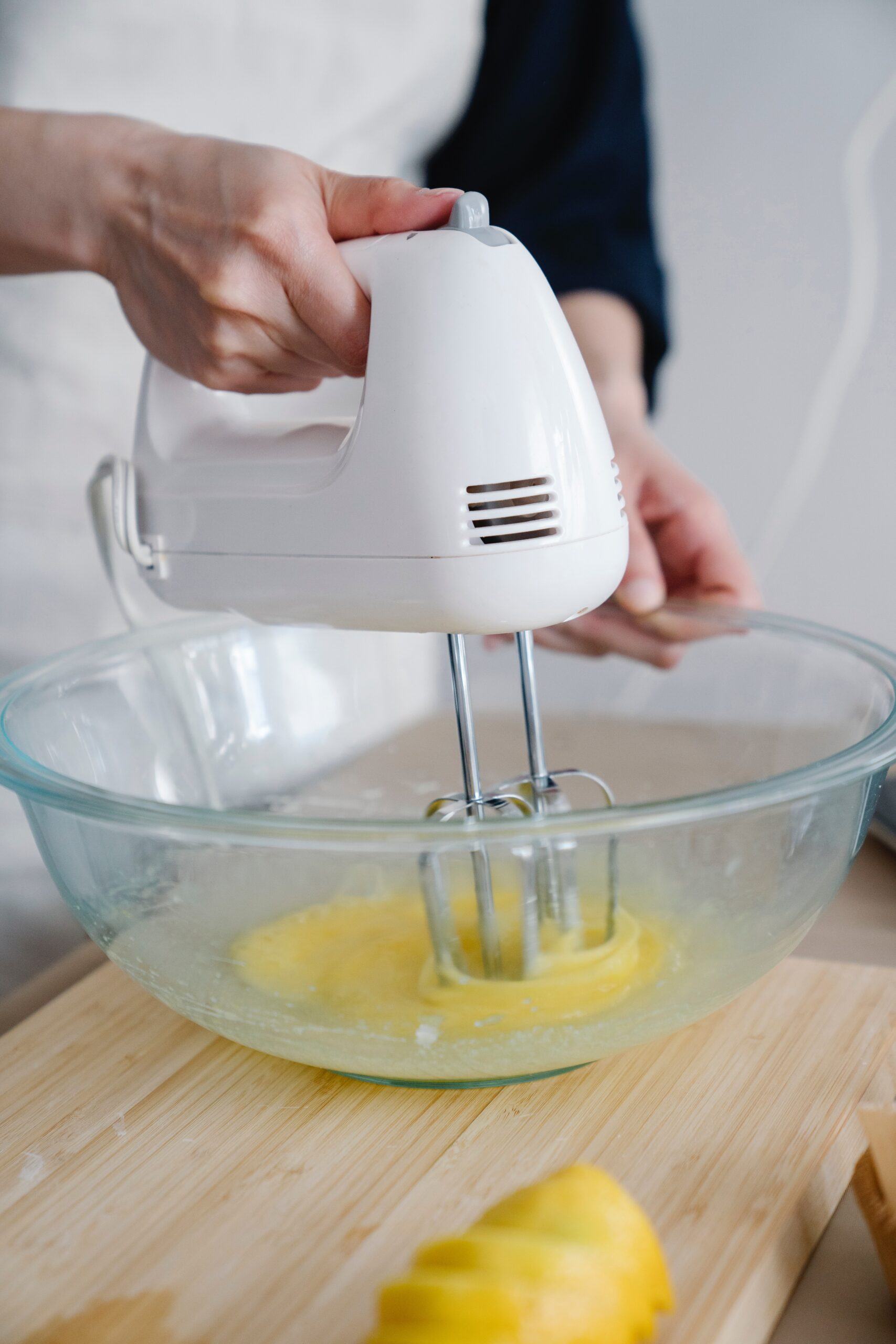 person using hand mixer to beat eggs